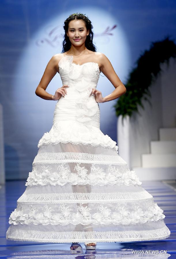 A model presents a wedding gown designed by Ren Chunhua during China Fashion Week in Beijing, capital of China, Oct. 26, 2014.