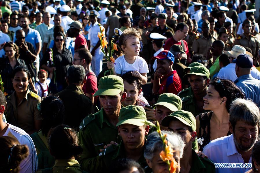 A girl prepares to offer flowers during a ceremny commemorating Camilo Cienfuegos in Havana, capital of Cuba, on Oct. 28, 2014.