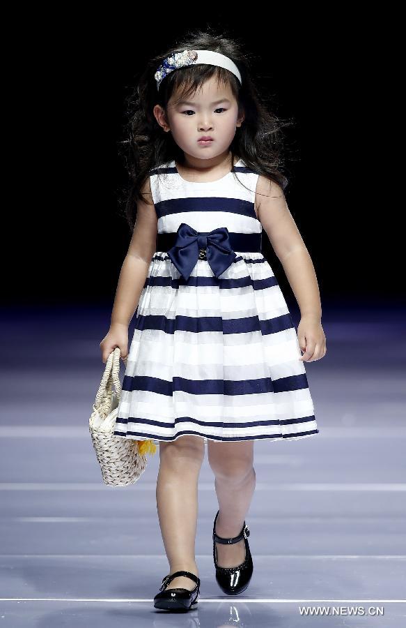 A child model presents a creation designed by Dong Wenmei during China Fashion Week in Beijing, capital of China, Oct. 29, 2014. [Xinhua]