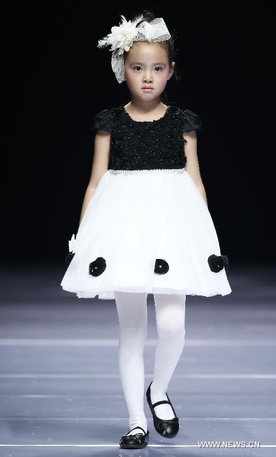 A child model presents a creation designed by Dong Wenmei during China Fashion Week in Beijing, capital of China, Oct. 29, 2014. [Xinhua]