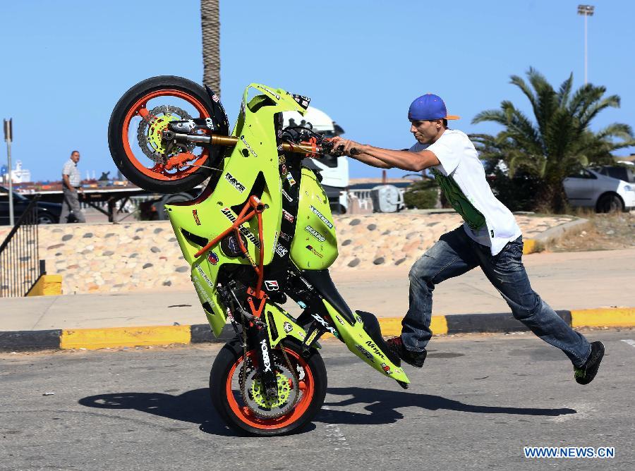 A Libyan young man shows his motorcycle riding skills on a motorway in Tripoli, Libya, Oct. 30, 2014. 