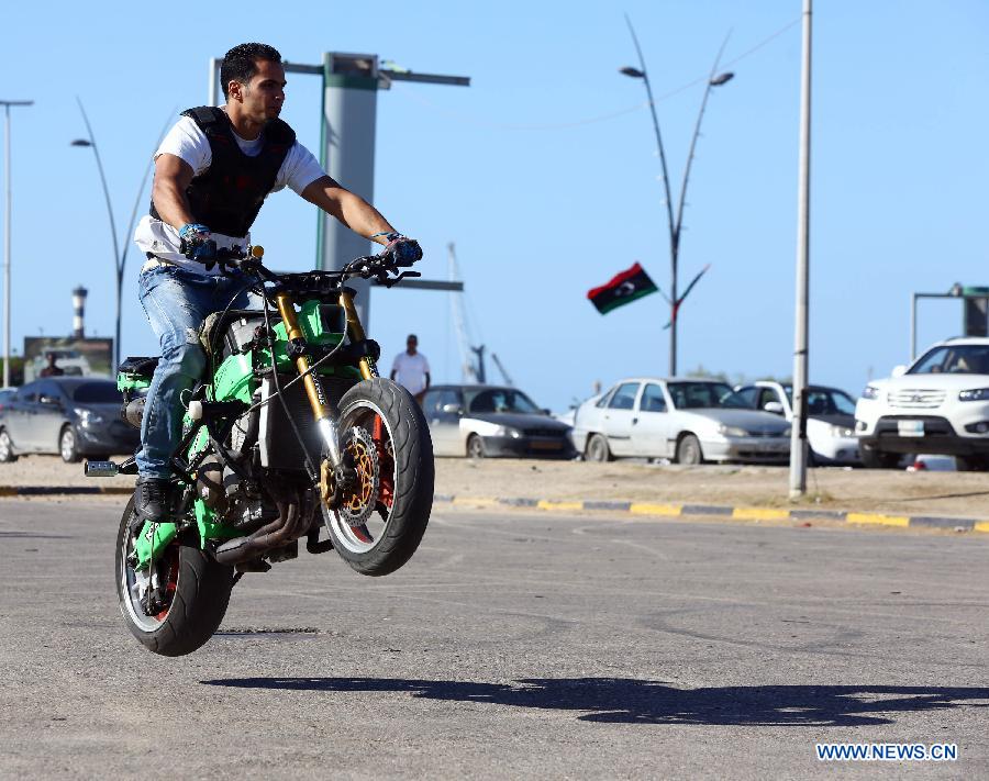 A Libyan young man shows his motorcycle riding skills on a motorway in Tripoli, Libya, Oct. 30, 2014. 