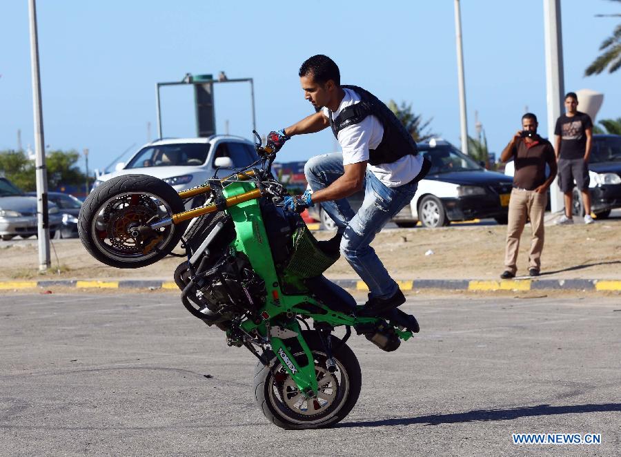 A Libyan young man shows his motorcycle riding skills on a motorway in Tripoli, Libya, Oct. 30, 2014. 