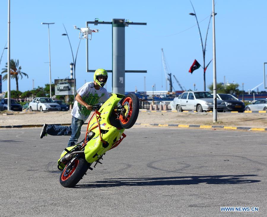 A Libyan young man shows his motorcycle riding skills on a motorway in Tripoli, Libya, Oct. 30, 2014. 