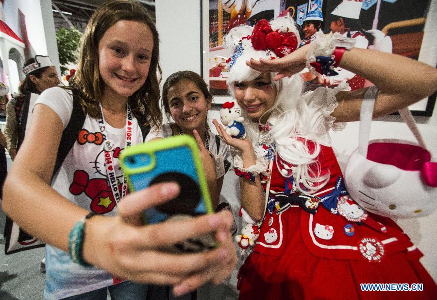 Fans take a selfie with a Hello Kitty model at the Hello Kitty Con, the first-ever Hello Kitty fan convention, in Los Angeles, the United States, Oct. 30, 2014. 