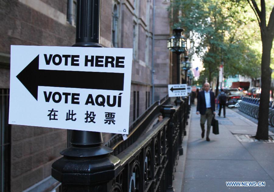 A citizen walks past a polling station in New York, the United States, on Nov. 4, 2014. The Midterm Elections were held here on Tuesday.