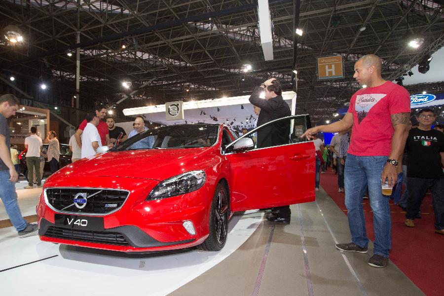 Visitors examine a Volvo 'V40' by China's Geely at the Sao Paulo Auto Exhibition in Sao Paulo, Brazil, Nov. 6, 2014.