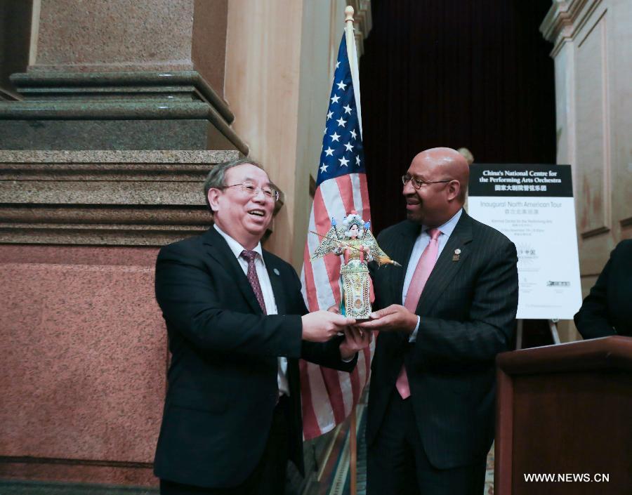 Chen Ping (L), head of National Centre for the Performing Arts of China, gives a gift to Michael Nutter, mayor of Philadelphia, at the City Hall in Philadelphia, the United States, on Nov. 6, 2014.