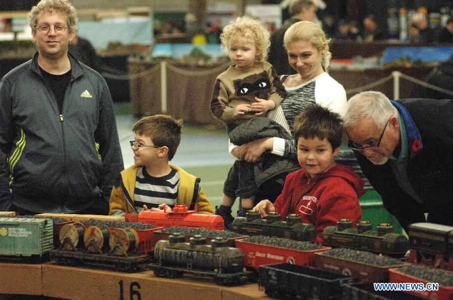 People watch model trains during the 32nd Model Railway Exhibition 'Trains 2014' in Burnaby, Canada, Nov. 8, 2014. 