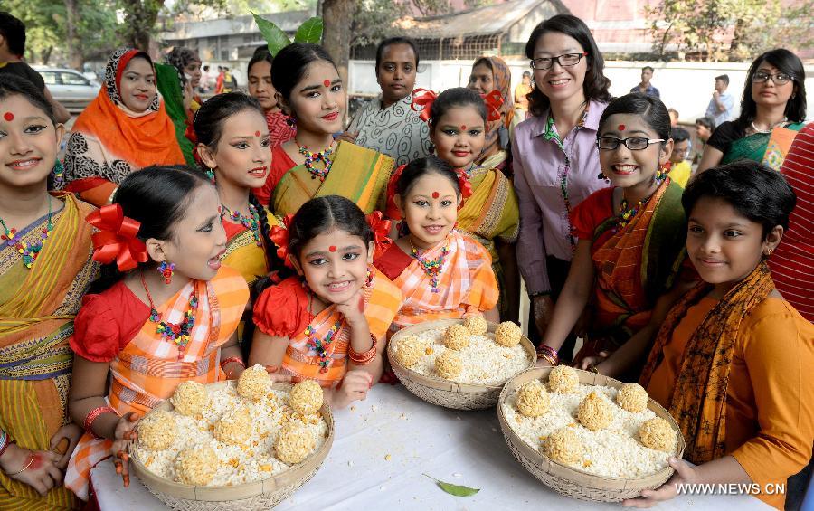 Bangladeshi people celebrate the traditional harvest festival on the first day of Agrahayan, a month of Bengali calendar, that falls on Saturday.