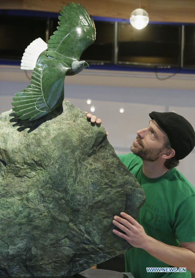 A jade enthusiast checks on an eagle-shaped jade sculpture at the World Jade Symposium in Vancouver, Canada, Nov. 21, 2014. 