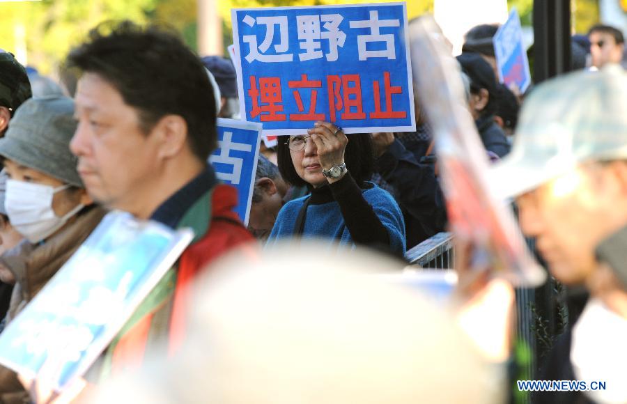 People hold banners to protest against U.S. bases in Okinawa in front of the Prime Minister's official residence in Tokyo, Japan, Nov. 22, 2014.
