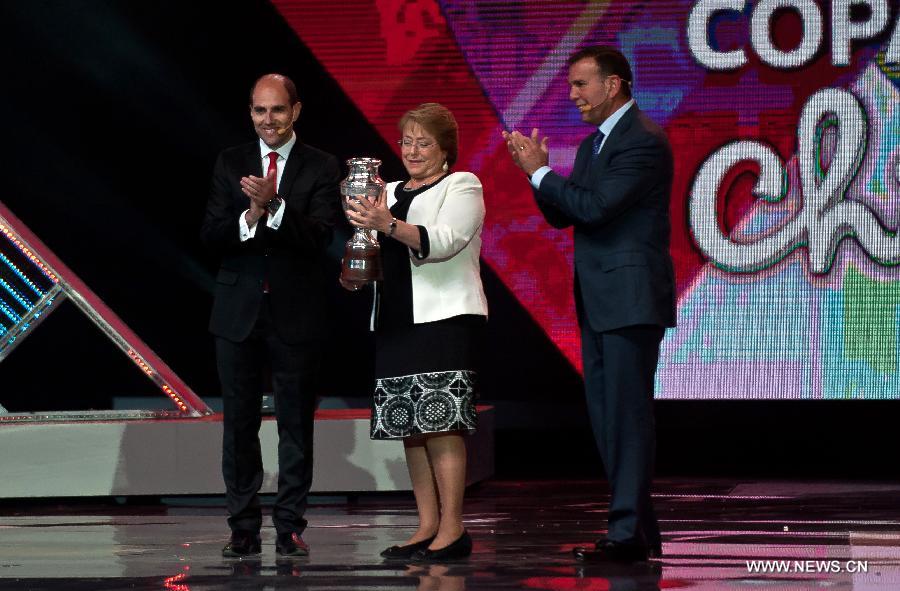 Chile's President Michelle Bachelet (C) receives a replica of the Copa America during the official draw, in Vina del Mar, Chile, on Nov. 24, 2014.