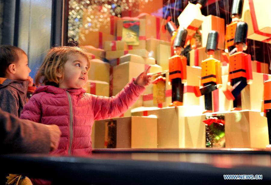 A girl looks at the puppets in the windows of a shopping mall in Paris, France, on Nov. 27, 2014. 