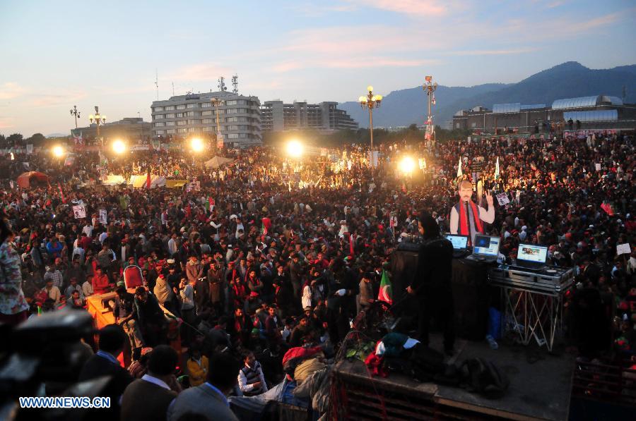 Supporters of Pakistan Tehrik-e-Insaf (PTI) or Justice Movement Party wave flags during an anti-government rally in front of the Parliament in Islamabad, capital of Pakistan, on Nov. 30, 2014. Pakistan's influential political leader Imran Khan, who leads the PTI, on Sunday gave a country's shutdown call on December 16 as part of his anti-government protest plan. (Xinhua/Ahmad Kamal) 