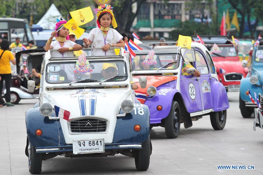 People participate in antique cars parade as part of the celebration of Thai King's 87th Birthday Anniversary in front of Grand Palace in Bangkok, Thailand, Dec. 4, 2014. 