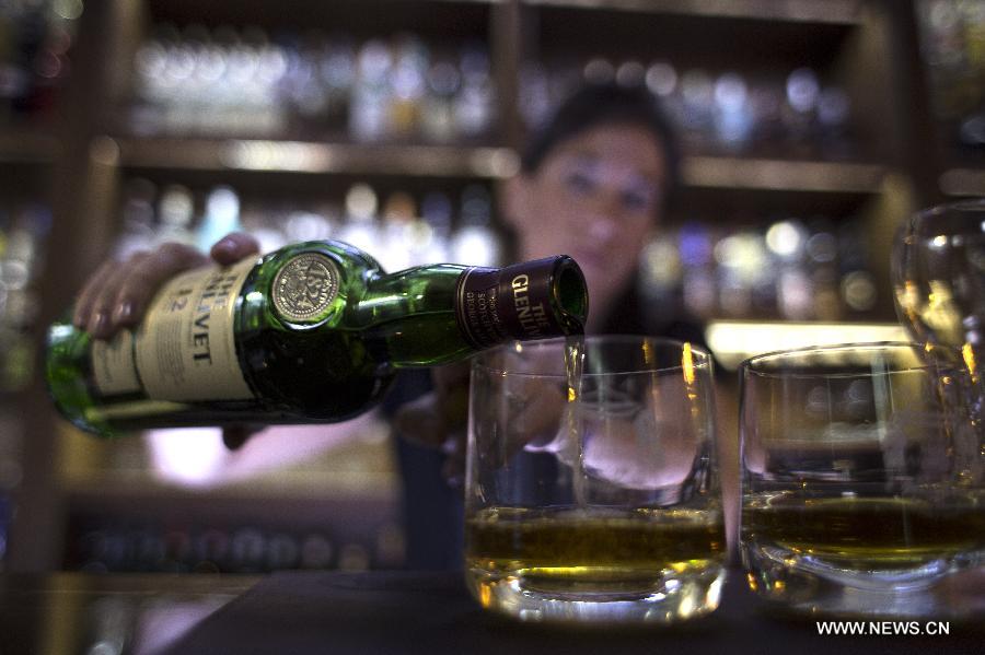 Veronica Tomaghelli, institutional ambassador of the whisky club 'Whisky Malt Argentina', serves a whisky in the Museum of Whisky in Buenos Aires, capital of Argentina, on Dec. 4, 2014.