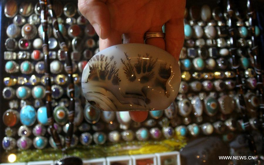 A vendor shows a stone at a gems stall on the last day of Gems and Jewellery Exhibition in northwest Pakistan's Peshawar on Dec. 7, 2014. 