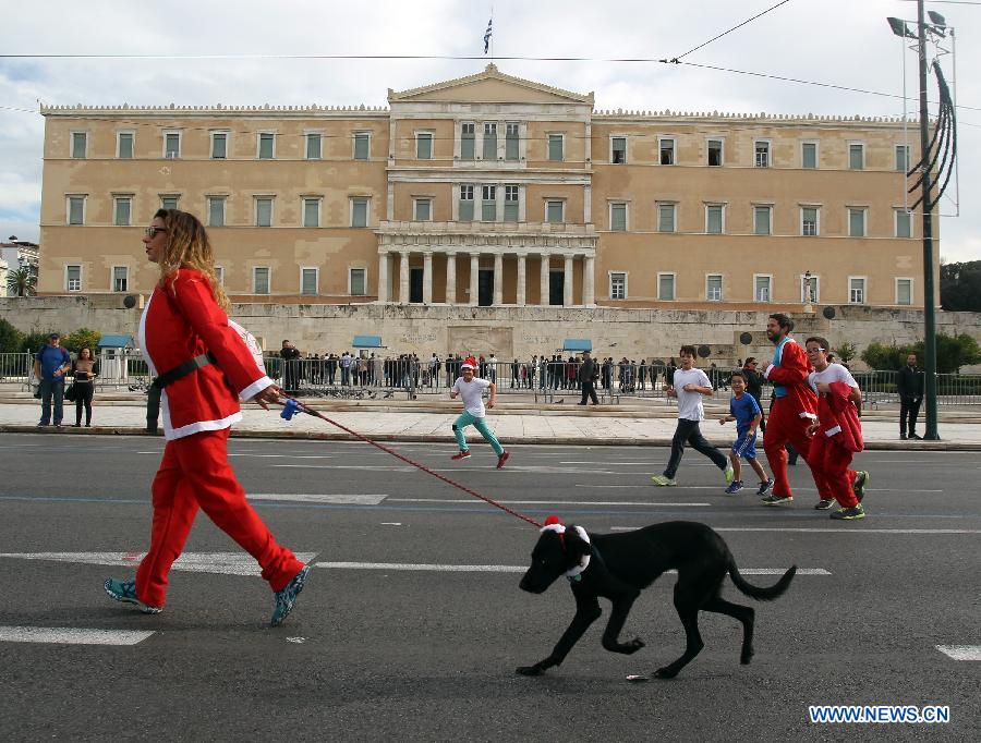 Runners wearing Santa Claus suits run in front of the Greek parliament during the first 'Santa Run' race in Athens, capital of Greece, Dec. 7, 2014. 