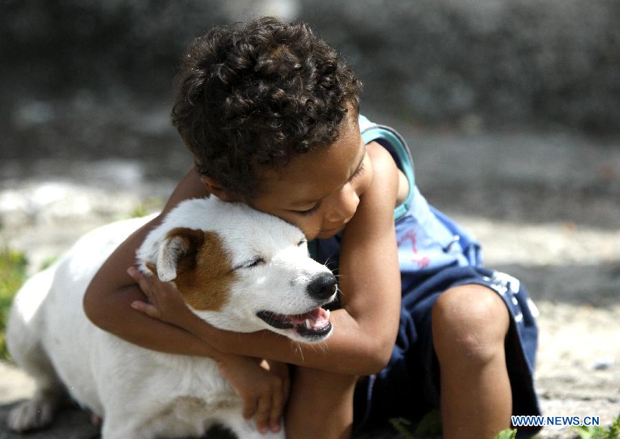 Miguel hugs the dog named Pitucha in Ibiritem in the metropolitan area of Belo Horizonte, Minas Gerais, Brazil, on Dec. 11, 2014.