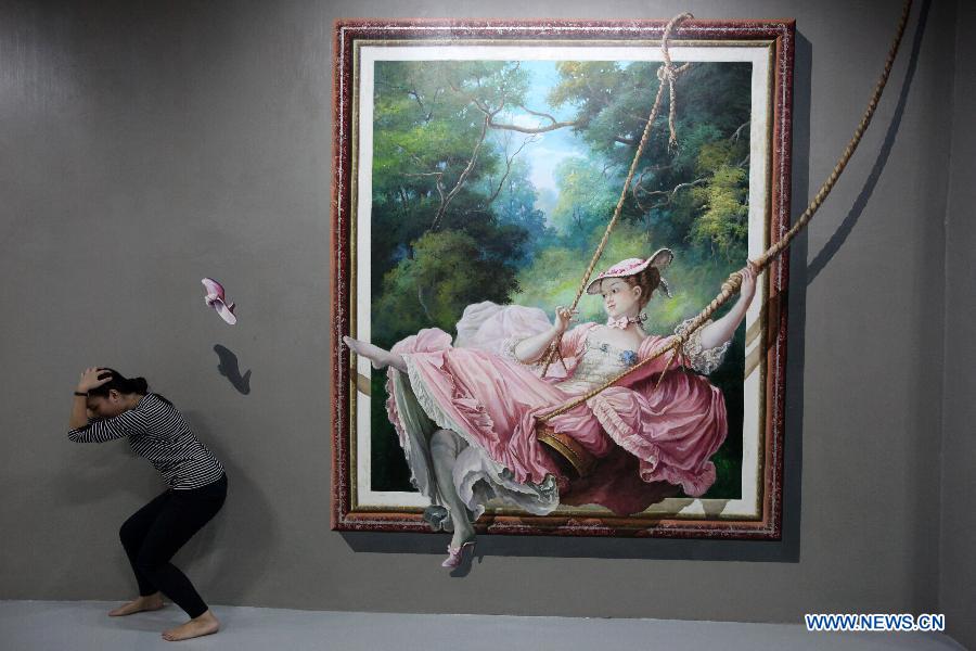 A woman poses with a 3D painting at the Art in Island in Quezon City, the Philippines, on Dec. 17, 2014.