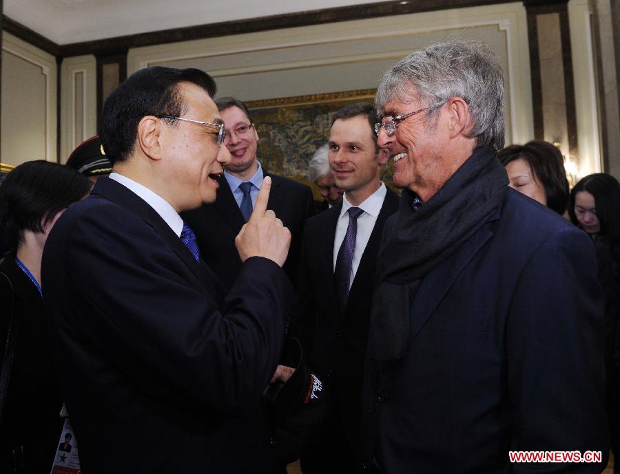 Chinese Premier Li Keqiang (L, front) talks with famous soccer coach Bora Milutinovic in Belgrade, Serbia, Dec. 18, 2014. Li was presented the charter of honorary citizen of Belgrade on Thursday afternoon and exchanged views with some distinguished Serbian personages on expanding bilateral cooperation in such areas as culture and sports. (Xinhua/Rao Aimin)