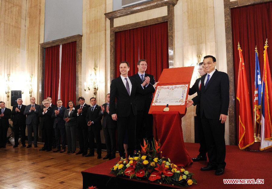 Chinese Premier Li Keqiang (R) receives the Belgrade honorary citizen charter at the Belgrade City Assembly in Belgrade, Serbia, Dec. 18, 2014. Li was presented the charter of honorary citizen of Belgrade on Thursday afternoon and exchanged views with some distinguished Serbian personages on expanding bilateral cooperation in such areas as culture and sports. (Xinhua/Rao Aimin)