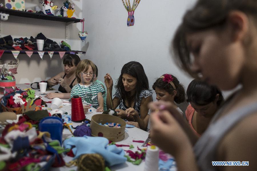 Volunteers create hand puppets that will be donated to children from low-income family in the 'Si' Foundation Toy Factory in Buenos Aires City, capital of Argentina, on Dec. 21, 2014. Up until now, over 5,600 toys created by around 6,000 volunteers have been sent to children in different cities in Argentina, according to local media.(Xinhua/Martin Zabala)