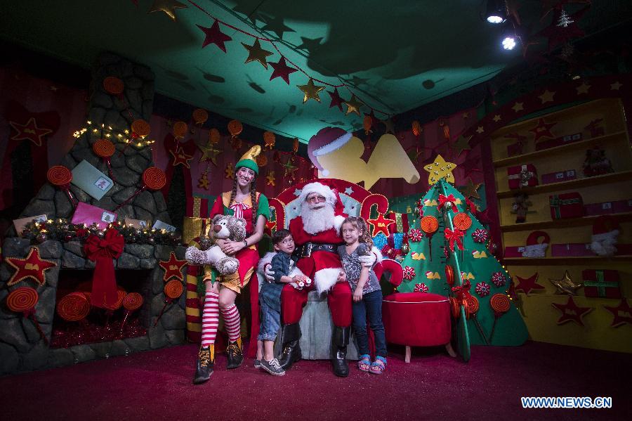 Children pose with Santa Claus in the Christmas Park in Buenos Aires City, capital of Argentina, on Dec. 21, 2014. (Xinhua/Martin Zabala)