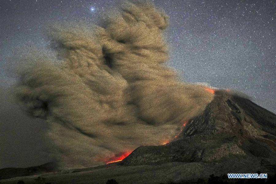 This long exposure photo taken before dawn on Oct. 14, 2014 shows sparks of lightning, scorching lava flow and giant ash clouds released from the crater during the eruption of Mount Sinabung volcano as seen from Karo district located in Sumatra island, Indonesia. 