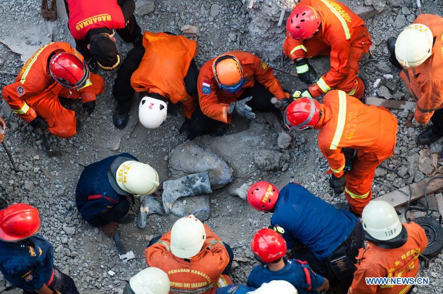 Rescuers gather around the body of a victim during an operation in Jakarta, Indonesia, Oct. 31, 2014.