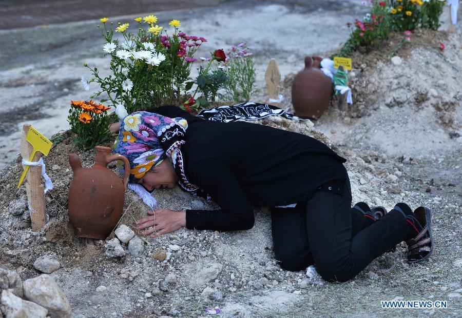 A woman cries on a victim's grave in a cemetery in Soma of Manisa, Turkey, on May 15, 2014. 