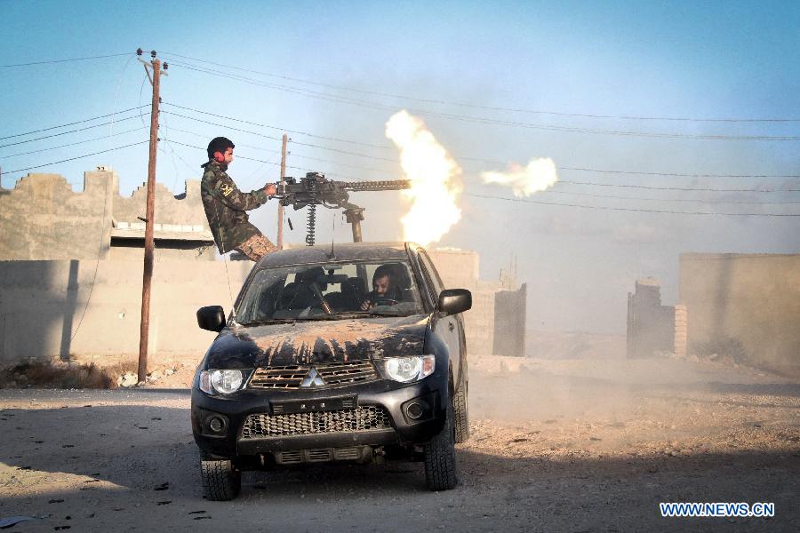 A Libya Dawn fighter fires a machine gun mounted on a vehicle in Kikla, Libya, on Oct. 21, 2014.