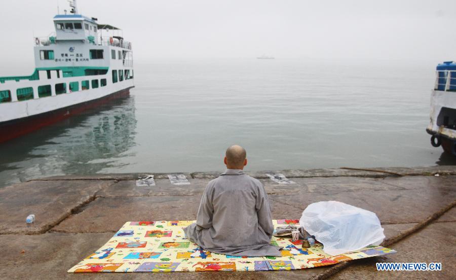 A monk prays for the missing passengers aboard the sunken vessel Sewol in Jindo, South Korea, April 18, 2014. 