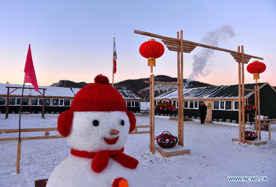 A snowman is seen in front of houses built for timberjacks the Moridaga Forestry Bureau in Dahinggan Mountain forest region in north China's Inner Mongolia Autonomous Region, Dec. 28. 2014.