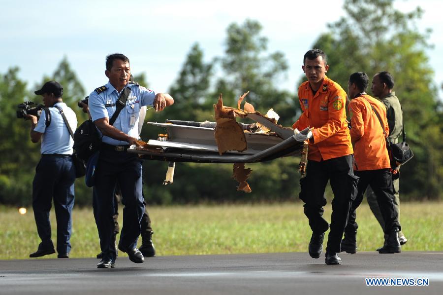 Search and Rescue (SAR) personnel and TNI officers carry the debris of AirAsia flight QZ8501 from helicopter at Iskandar Air Base, in Pangkalan Bun, Central Kalimantan, Indonesia, Jan. 2, 2015.