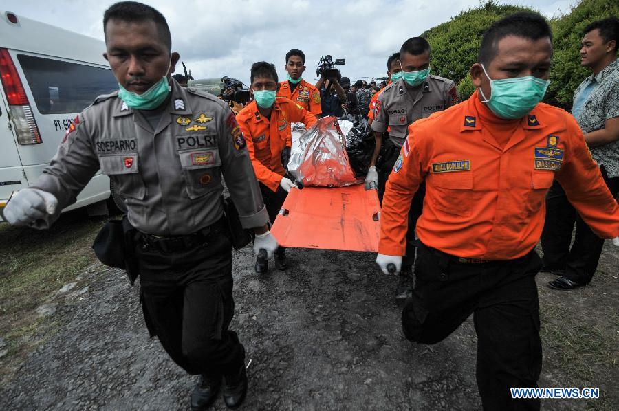 Search and Rescue (SAR) personnels and policemen carry the debris of AirAsia flight QZ8501 from a USS Navy helicopter at Iskandar Air Base, in Pangkalan Bun, Central Kalimantan, Indonesia, Jan. 2, 2015. 