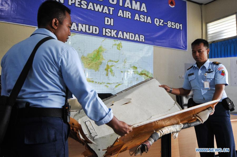 Search and Rescue (SAR) personnel and TNI officers carry debris of AirAsia flight QZ8501 from helicopter at Iskandar Air Base, in Pangkalan Bun, Central Kalimantan, Indonesia, Jan. 2, 2015.