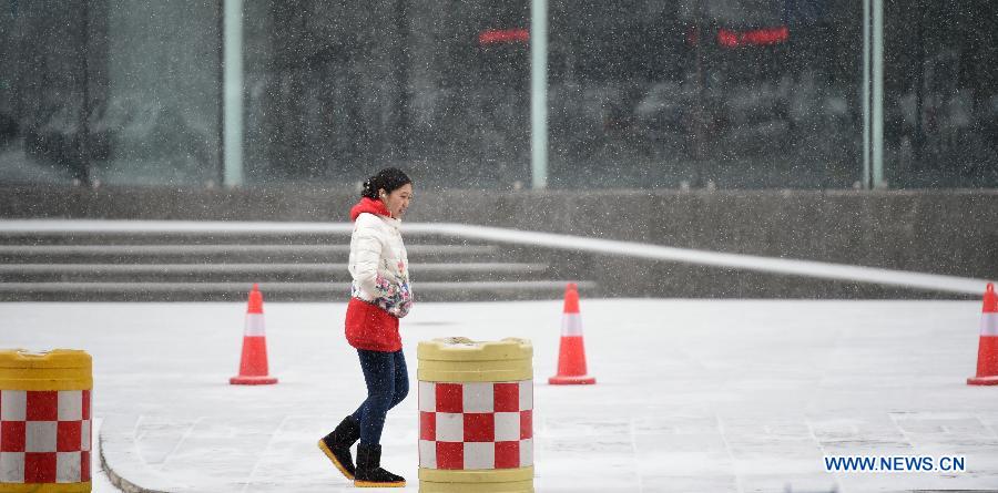 A woman walks in snow in Shenyang, capital of northeast China's Liaoning Province, Jan. 5, 2015. The city's meteorological station issued a blue alert for cold wave on Monday. (Xinhua/Yao Jianfeng) 