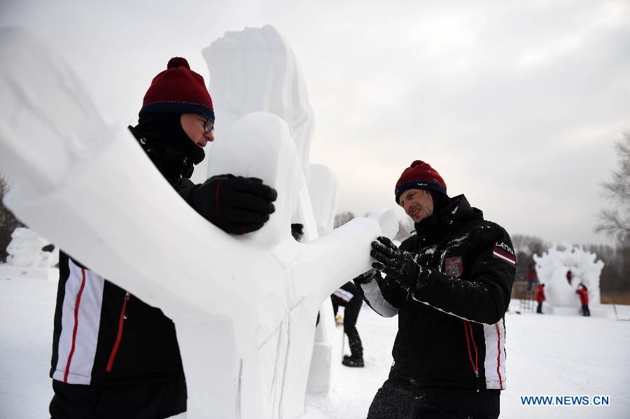 Latvian sculptors work on a snow sculpture at the 20th Harbin International Snow Sculpture Contest in Harbin, capital of northeast China's Heilongjiang Province, Jan. 13, 2015. 