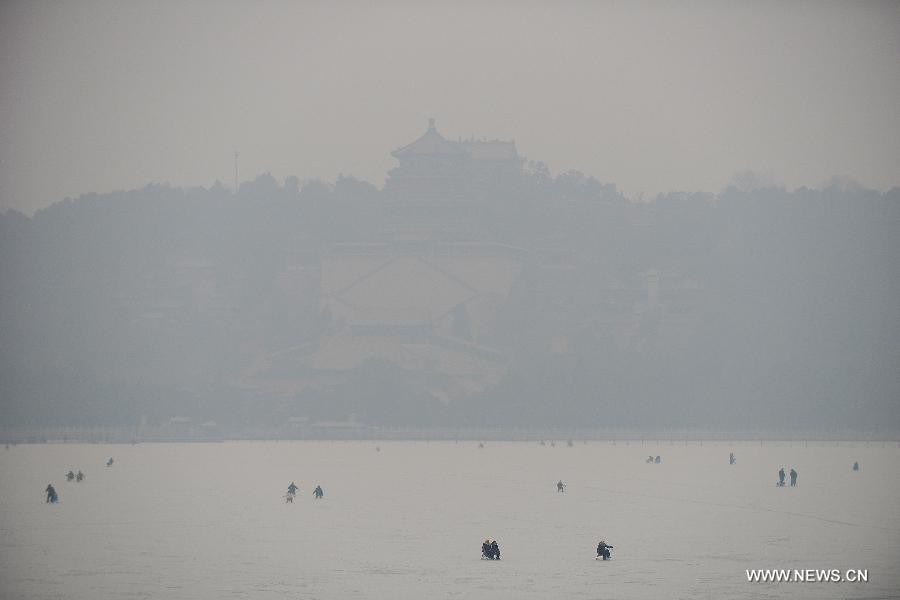 Tourists play on the frozen Kunming Lake in the Summer Palace of Beijing, capital of China, Jan. 14, 2015. Beijing on Wednesday saw a snowfall while the city was enveloped by heavy smog. The city's meteorological station recorded snowfall of less than 1 millimeter in the morning, with the snow likely to continue into the evening. (Xinhua/Li Xin)