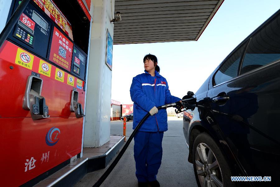 A worker fills up a car with fuel at a gas station in Cangzhou, north China's Hebei Province, Feb. 9, 2015. 