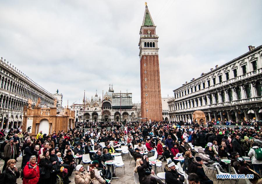 Tourists and revellers gather at St Mark's square during the Venice Carnival in Venice, Italy, on February 13, 2015. 