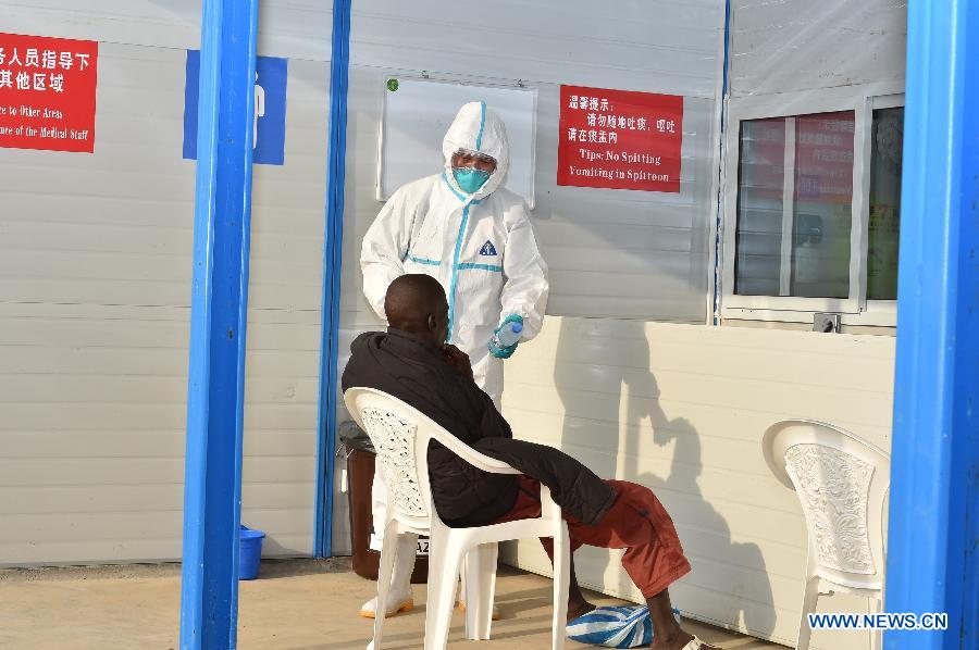 A member of Chinese Medical Team to Liberia takes care of a local patient in Monrovia, Liberia, Dec. 6, 2014. Since the outbreak of Ebola Virus Disease, China provided its aid in the first time and so far has sent successively several medical teams and four batches of emergency aid worth a total of 700 million yuan (around 112.2 million U.S. dollars) to the epidemic-hit countries, becoming one of the biggest donors to the infected areas and playing an important role in coping with the epidemic.(Xinhua/Jiang heng) 