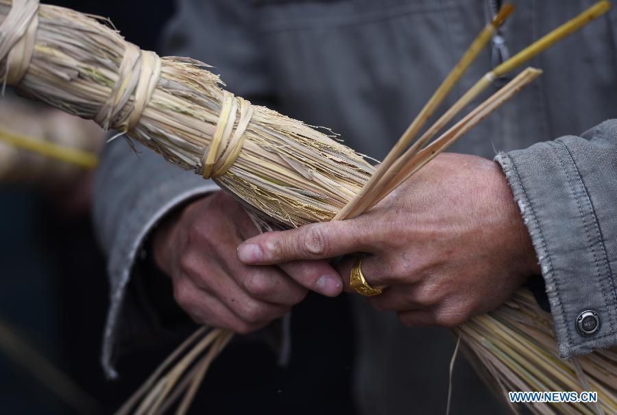 A villager weaves straw bundles to perform bullfight dance called 'Huoxianniu' (fire fairy cattle) in Zhengyuan Village of Qidu Township in Chenzhou City, central China's Hunan Province, March 3, 2015. Local villagers, who has a tradition to worship farm cattle, followed the custom to tie red flowers on cattle and perform bullfight dance with straw bundles which are inserted with litten incenses on the 13th day of the first month of the lunar year. (Xinhua/Li Ga) 