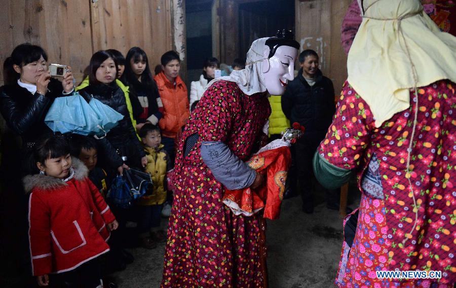 Local people watch traditional Nuo dance to celebrate Chinese lunar New Year in Sanxi Township of Nanfeng County, east China's Jiangxi Province, March 4, 2015. Nuo dance used to be sacrificial rituals staged during festivals in the ancient times to expel evil spirits and pray for good harvests.(Xinhua/Chen Zixia) 