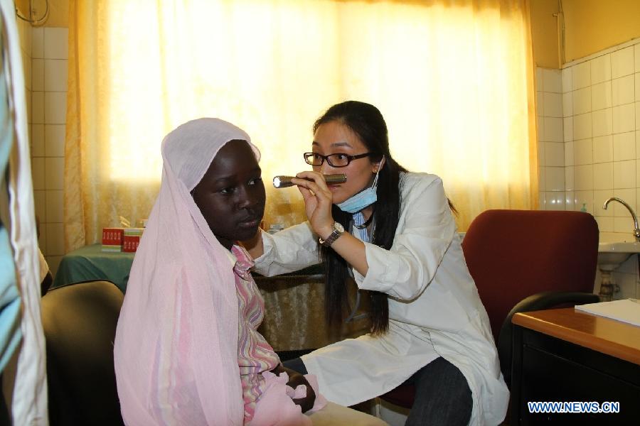 A doctor of Chinese medical team to Senegal examines the ear of a female patient at the Hann/Mer Medical Center in Darkar, capital of Senegal, March 31, 2013. Since the outbreak of Ebola Virus Disease, China provided its aid in the first time and so far has sent successively several medical teams and four batches of emergency aid worth a total of 700 million yuan (around 112.2 million U.S. dollars) to the epidemic-hit countries, becoming one of the biggest donors to the infected areas and playing an important role in coping with the epidemic. (Xinhua/Wang Meng) 