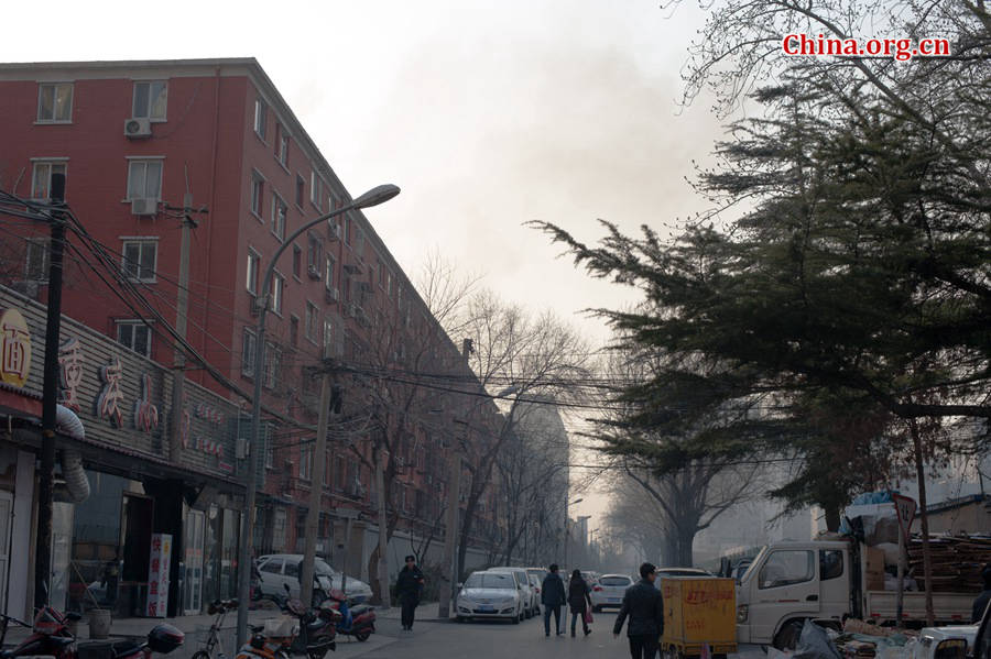 A building catches fire on Thursday, March 5, the traditional Chinese Lantern Festival. The building, according to people who live nearby, is used as a warehouse of Gehua, Beijing's local cable TV service provider, and the burning rubber from the cable gives out a strong black smoke. [Photo by Chen Boyuan / China.org.cn]