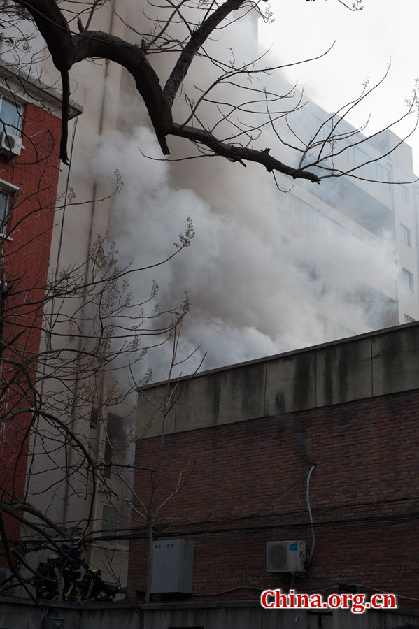 A building catches fire on Thursday, March 5, the traditional Chinese Lantern Festival. The building, according to people who live nearby, is used as a warehouse of Gehua, Beijing's local cable TV service provider, and the burning rubber from the cable gives out a strong black smoke. [Photo by Chen Boyuan / China.org.cn]