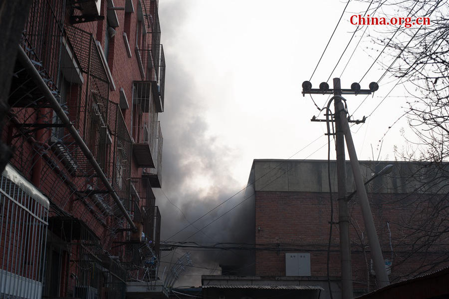 A building catches fire on Thursday, March 5, the traditional Chinese Lantern Festival. The building, according to people who live nearby, is used as a warehouse of Gehua, Beijing's local cable TV service provider, and the burning rubber from the cable gives out a strong black smoke. [Photo by Chen Boyuan / China.org.cn]